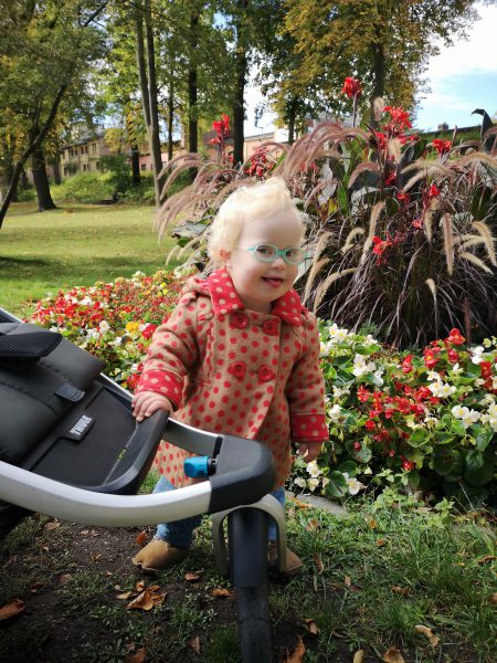 Baby mit Down Syndrom im Garten
